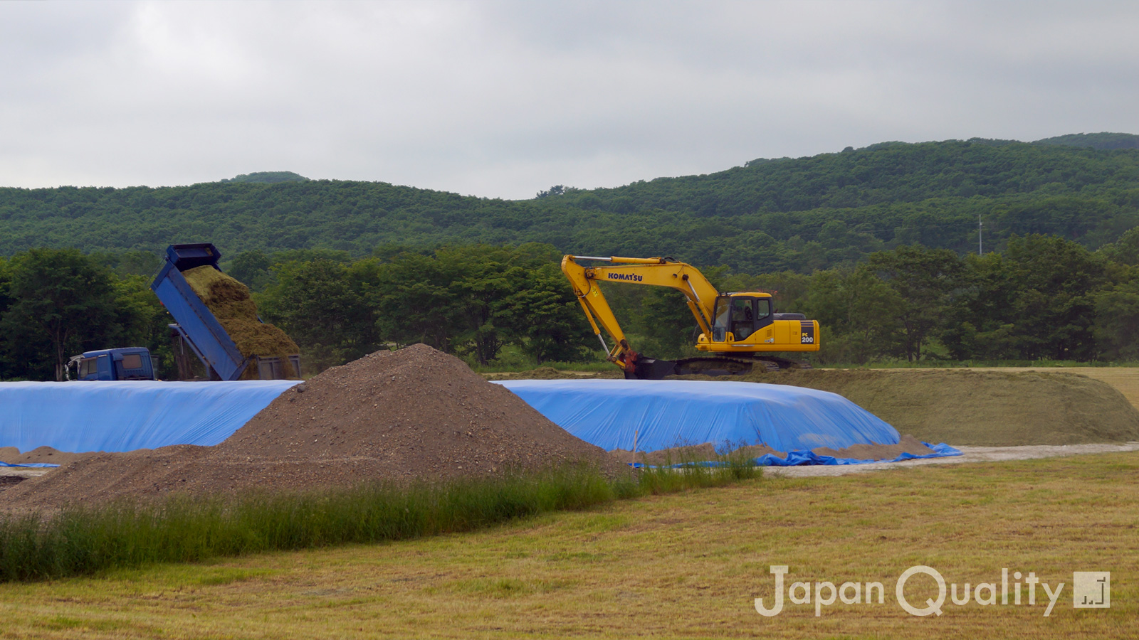 牧草を積み、踏圧している最中のスタックサイロ